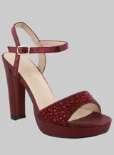 Sandalia de fiesta color borgoña con plataforma y taco alto cuadrado. Presenta una tira ancha sobre los dedos y pulsera al tobillo, ambas adornadas con strass.