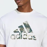Remera de algodón blanca de manga corta, con cuello redondo y un gran logo Badge of Sport de Adidas estampado en el centro del pecho con diseño de camuflaje en tonos verde militar, gris y beige.