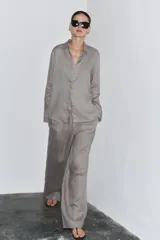 Pantalón palazzo color ladrillo, confeccionado en lino 100%, de tiro medio, cintura ajustable con cordones, bolsillos laterales ocultos y pierna ancha.