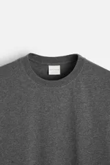 Camiseta gris de corte recto, cuello redondo y manga corta.