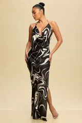 Vestido largo negro con estampado abstracto en blanco, escote cowl halter y abertura lateral en la pierna.
