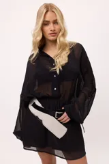 Vestido corto color verde lima, estilo camisero, confeccionado en chiffon transparente. Tiene cuello camisero, mangas largas abullonadas y elástico en la cintura.