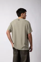 Remera color crudo de lino con textura entramada, calce cómodo y mangas cortas.