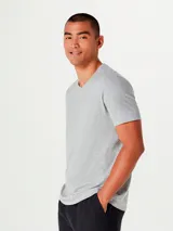 Camiseta básica unisex de color beige, con cuello en V y sin costuras laterales para mayor comodidad.