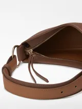 Bolso de hombro tipo baguette color crema, con textura granulada y asa corta regulable.