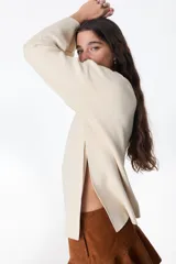 Sweater color crudo con bordado de flores rojas, amarillas y azules.