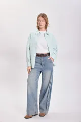 Camisa de manga larga con cuello clásico, corte recto y cierre frontal con botones. Diseño a rayas verticales finas en color verde agua y blanco.