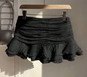 Minifalda negra con cintura elastizada y volados en el ruedo.