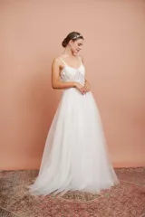 Vestido largo de microtul blanco con brillo y apliques de flores, con breteles finos y falda con vuelo. Ideal para quinceañeras.