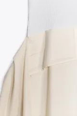 Vestido midi color crema, de escote redondo y tirantes finos. Tejido combinado a contraste. Detalle de tejido con frunces en lateral.