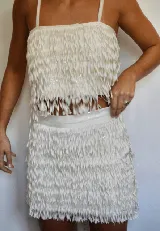 Top blanco con flecos y lentejuelas, de breteles finos y corte crop.