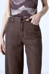 Pantalón de jean marrón con estampado de piel de serpiente, corte wide leg y tiro alto.