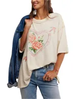 Remera color crema de corte holgado, con cuello redondo y mangas cortas. Estampado frontal con un corazón atravesado por una flecha y rosas rojas.