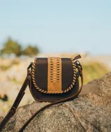 Cartera bandolera de cuero color marrón oscuro con detalles de cuero trenzado color beige en la solapa.