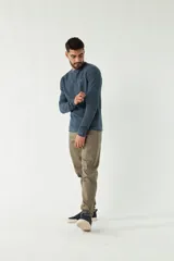 Sweater azul de punto con cuello redondo, mangas largas y logo bordado en el pecho. Corte slim fit.