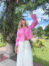 Camisa rosa de lino, de corte crop y mangas largas con puños elásticos.