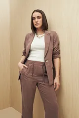 Pantalón beige de tiro medio con cintura elastizada y cordón regulable, bolsillos laterales y calce relajado.