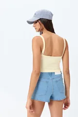 Short de jean de tiro alto, color celeste claro, con bolsillos frontales y traseros, y cierre frontal con botón metálico.