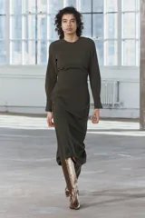 Vestido midi de cuello redondo y manga larga con puños. Tiene detalle de drapeado lateral y cierre trasero con cremallera oculta en la costura.