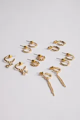 Pack de seis pares de aros dorados con diferentes diseños: aros tipo argolla con textura, aros con dije de estrella, aros con cadena colgante y aros lisos.