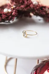 Anillo dorado con circonita transparente en forma de lágrima.