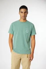 Remera de manga corta color verde menta con cuello redondo y un bolsillo en el pecho con un parche cuadrado azul con una 'X' blanca.