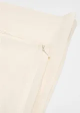 Pantalón de vestir color crudo, de corte recto y tiro medio, con cierre lateral de cremallera.