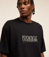 Remera negra de corte boxy con estampa frontal de Gasparin psicodélico.