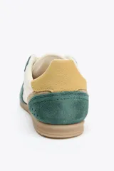 Championes deportivos de running con cuerpo en combinación de colores verde, beige y amarillo. Suela de goma color caramelo y cierre mediante cordones.