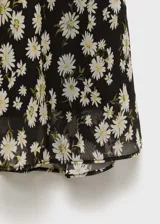 Falda midi negra de gasa con estampado de pequeñas flores blancas.