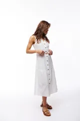 Vestido midi blanco de algodón con escote en V, abotonado al frente y cuello camisero. Cuenta con cinturón regulable con hebilla tipo carey.
