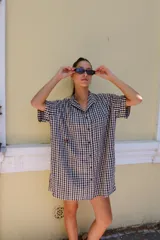 Vestido corto camisero a cuadros celestes y blancos, de corte amplio y cuello mao. Tiene botones a tono y logo bordado en el frente.