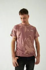 Remera color ladrillo con estampado abstracto en tonos beige y logo de la marca Mistral en el pecho.