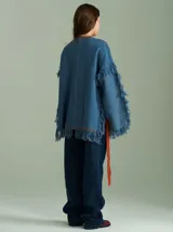 Sweater negro oversize de lana con cuello redondo, bordado central en forma de trenza, laterales con cuadrillé y mangas acampanadas desflecadas.