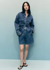 Short de algodón estilo tejano vaquero, color azul medio, de tiro medio y diseño recto con pinzas delanteras.