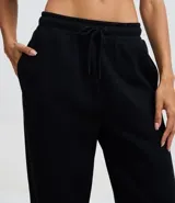 Pantalón recto femenino color negro, confeccionado en algodón con felpa, con cintura ajustable mediante cordón y caída suelta.