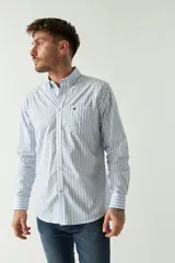 Camisa celeste a rayas rojas de hombre, manga larga, con bolsillo y logo bordado.