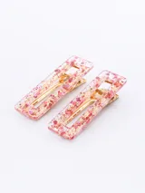 Set de dos broches rectangulares para el pelo con diseño de carey en tonos crema y blanco, y gancho dorado.