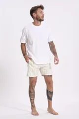 Short de baño color rosa con estampado de hojas y flores en tonos verdes, marrones y blancos.