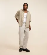 Pantalón baggy jeans color gris claro, con cierre de botón y cremallera, y bolsillos laterales y traseros.