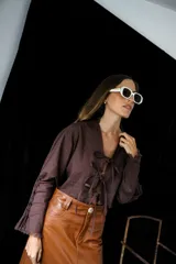 Camisa corta color rojo con escote en V y mangas largas acampanadas. Presenta ajuste frontal con lazos.