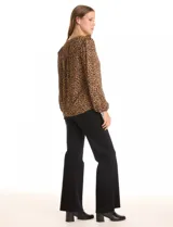 Blusa de gasa estampada con animal print, cuello a la base con escote en V y cierre dorado. Manga larga con puño elastizado.