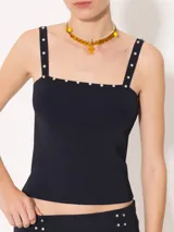 Top negro ajustado al cuerpo, con breteles finos y detalle de piedras en el escote.