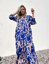 Vestido largo con estampado abstracto en azul y crudo, con escote en V y mangas 3/4.