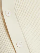 Cardigan de punto color crema con botones. Corte clásico y amplio.