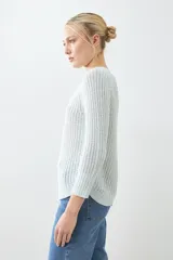 Sweater rojo de tejido de punto con ruedo curvo y mangas 3/4.
