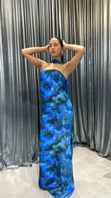 Vestido largo strapless con estampado abstracto en tonos azules y negros. Presenta un tajo lateral y un choker al tono.
