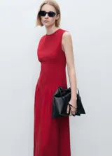 Vestido midi rojo sin mangas, con cuello redondo y corte evasé. Presenta pinzas en la cintura y cierre de cremallera y botón en la parte posterior.