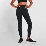 Calza larga de training New Balance modelo Harmony High Rise, color negro, con cintura alta y logo reflectivo en la pierna.