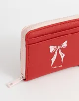 Billetera de cuerina color blanco con estampado de corazones rosas y lazos azules, cierre perimetral con cremallera y múltiples ranuras para tarjetas.
